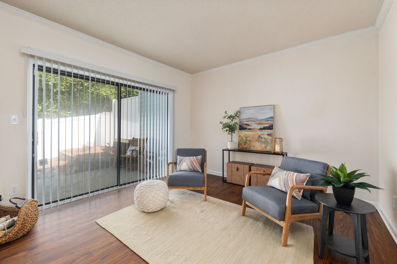 Bright modern living room featuring stylish armchairs, decor, and wooden flooring.